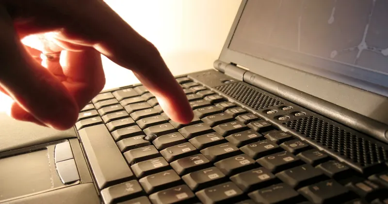 Hand an einer Laptop-Tastatur
