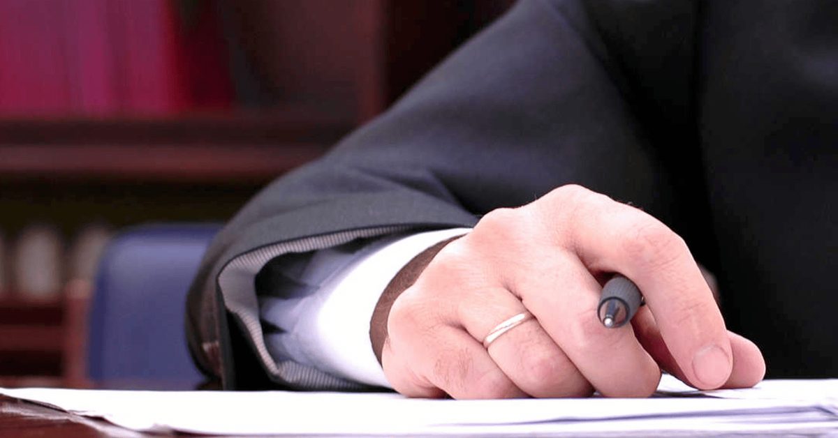 Hand schreibt Notizen mit einem Stift